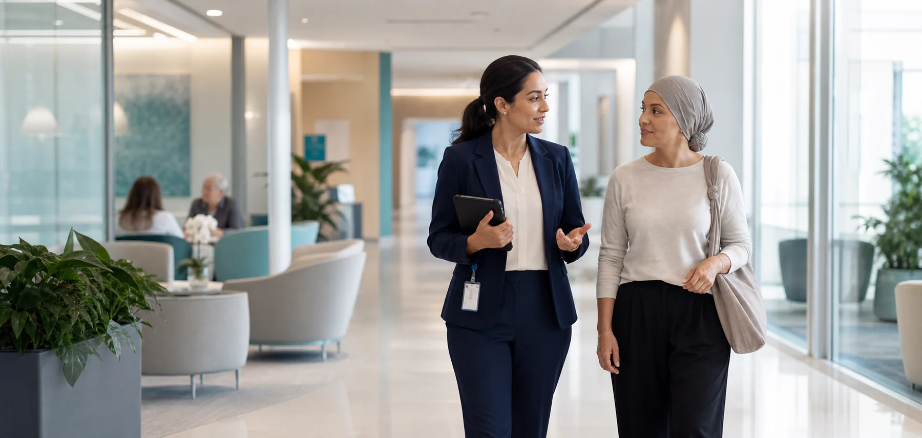 A care coordinator walking with a patient in a calm oncology center.